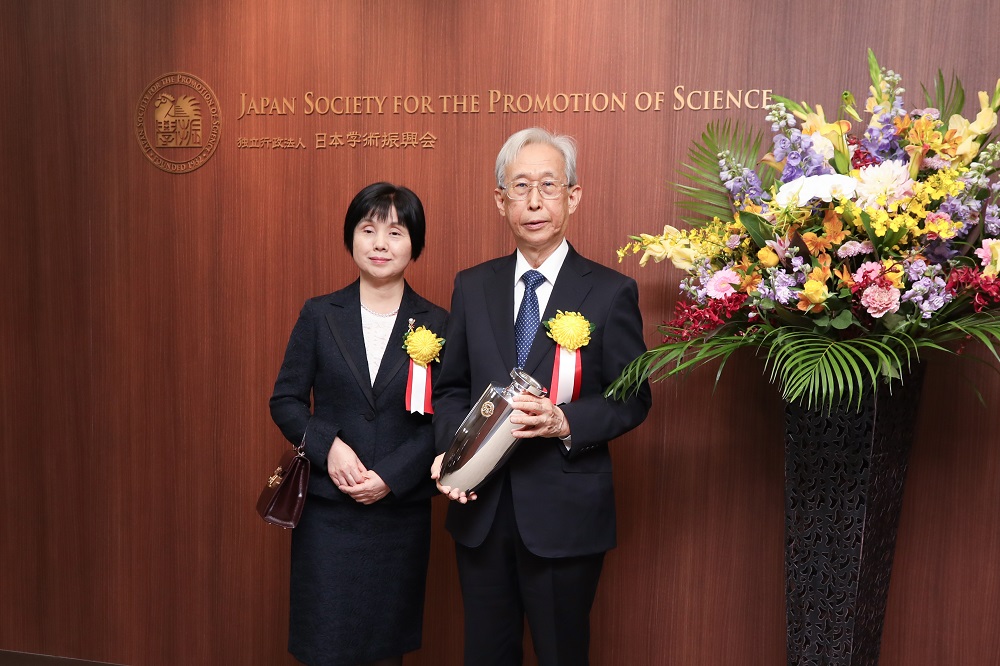 Dr. Shinozaki with his wife holding the congratulatory gift