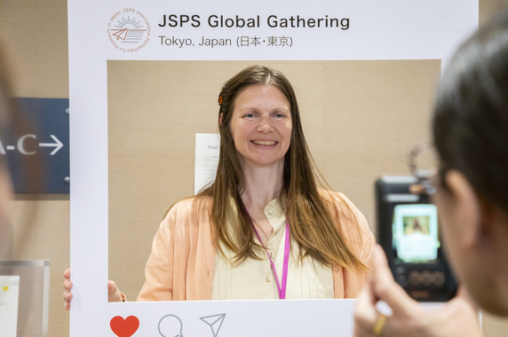 シンボルマーク入りのパネルを使って記念撮影する様子