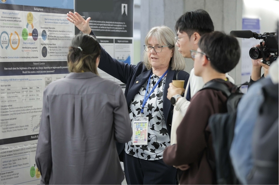 ポスター発表を聞くストリックランド博士