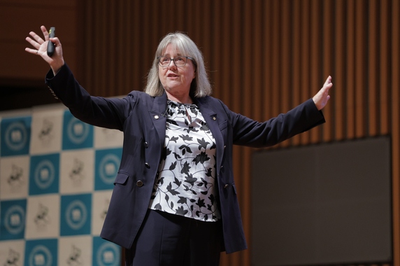 Dr. Strickland lecturing with expressive gestures on stage