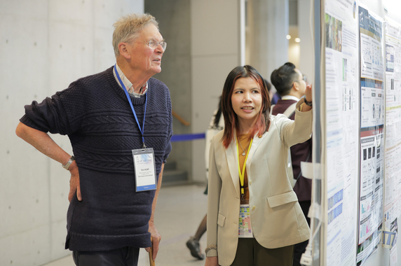 Two researchers discussing in front of a poster display