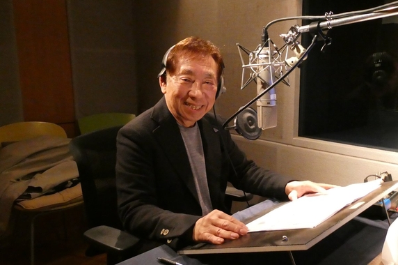 ヘッドホンを着けてナレーション収録を行う窪田等さん
