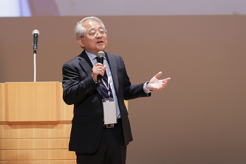President SUGINO speaks at the podium with a smile