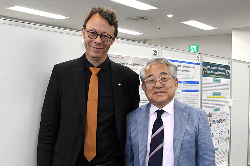 杉野理事長とCNRSのFrédéric HERAU氏が並んで笑顔でカメラに向かう様子