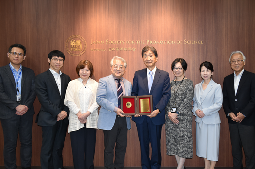 Former President Anzai with JSPS staff holding his award