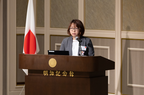 壇上のマイクに向かって、参加者に研究内容を語る特別研究員-RPD