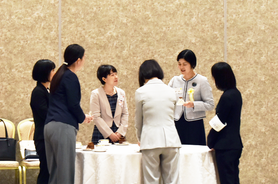 白いクロスのかかった円卓を囲んで、女性6名が交流・情報交換を行う様子